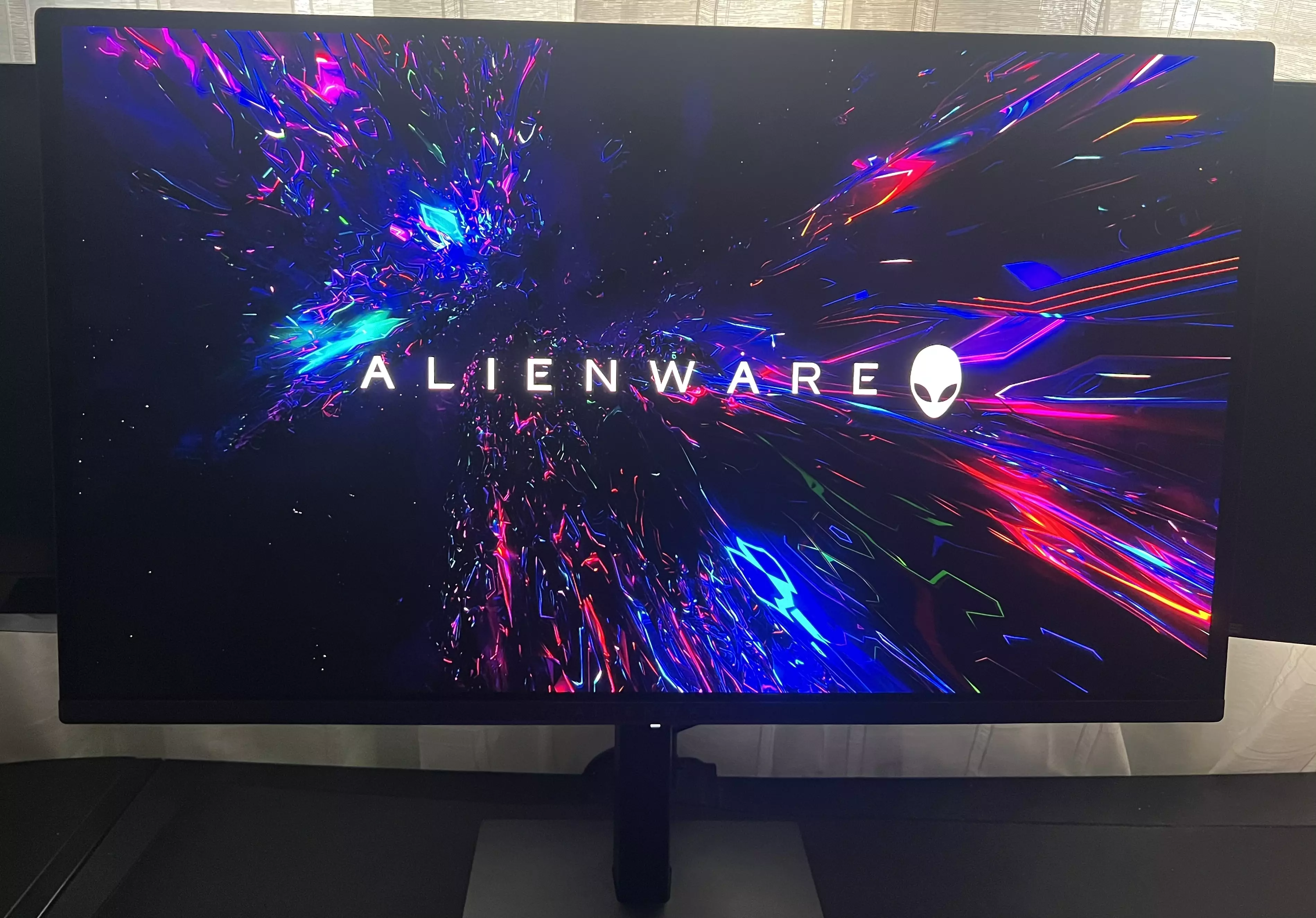 Alienware AW2726DM allumé avec le logo Alienware coloré à l'écran