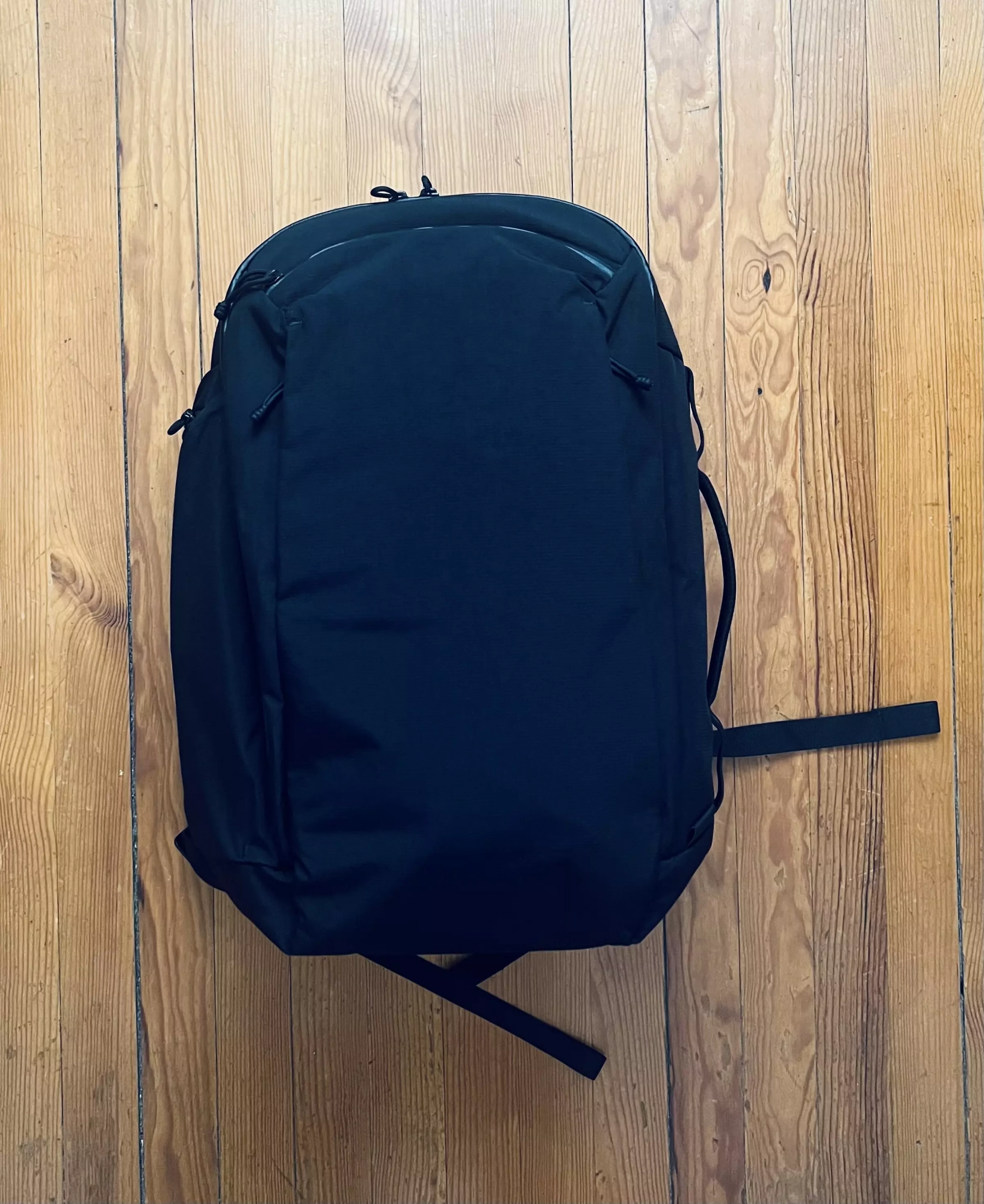Face avant de l'ALPAKA Traverse 38L noir, sac rempli, logo discret et fermetures intégrées