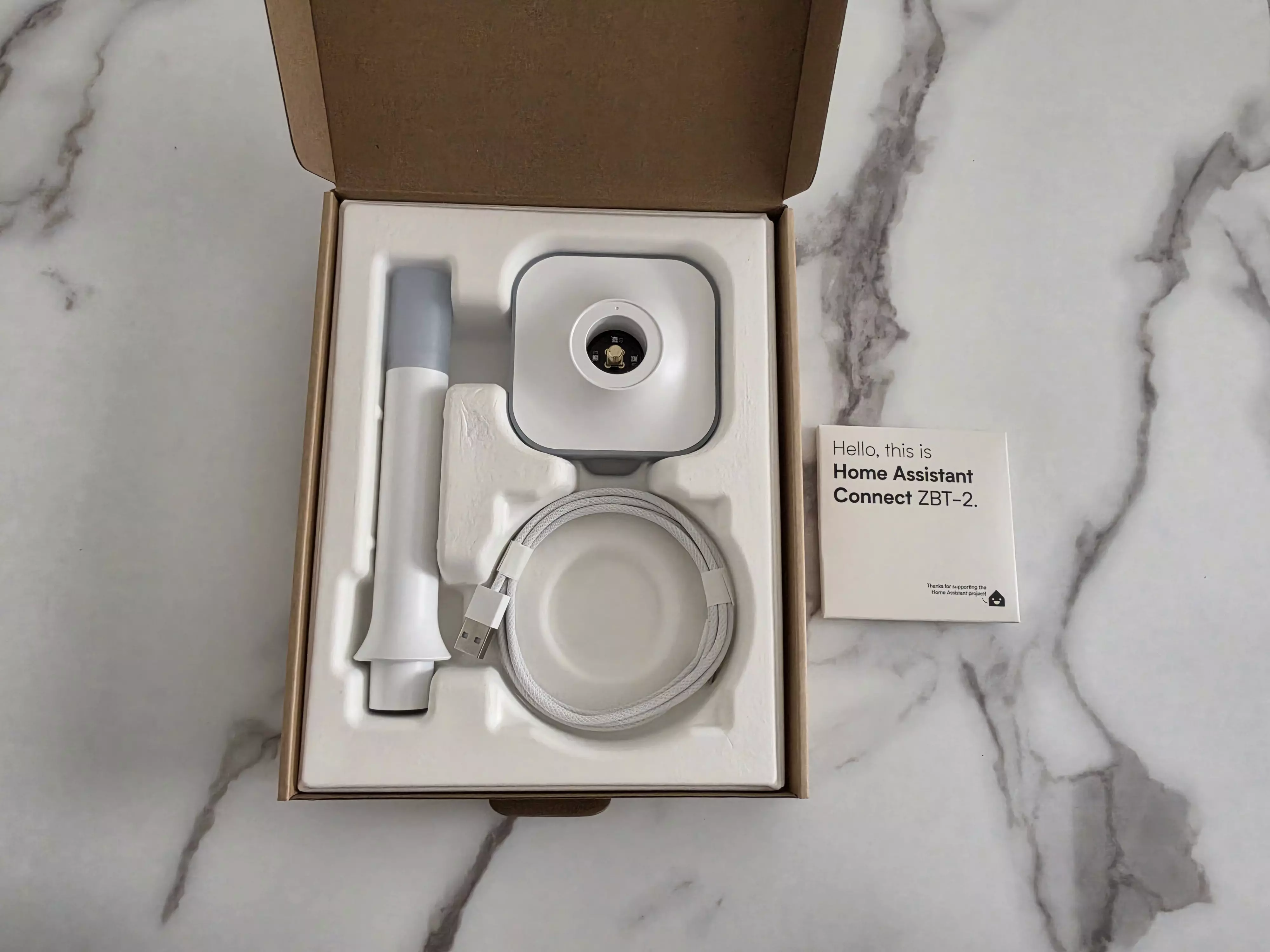 Boîte ouverte du Home Assistant Connect ZBT-2 avec sa base, son antenne et son câble USB