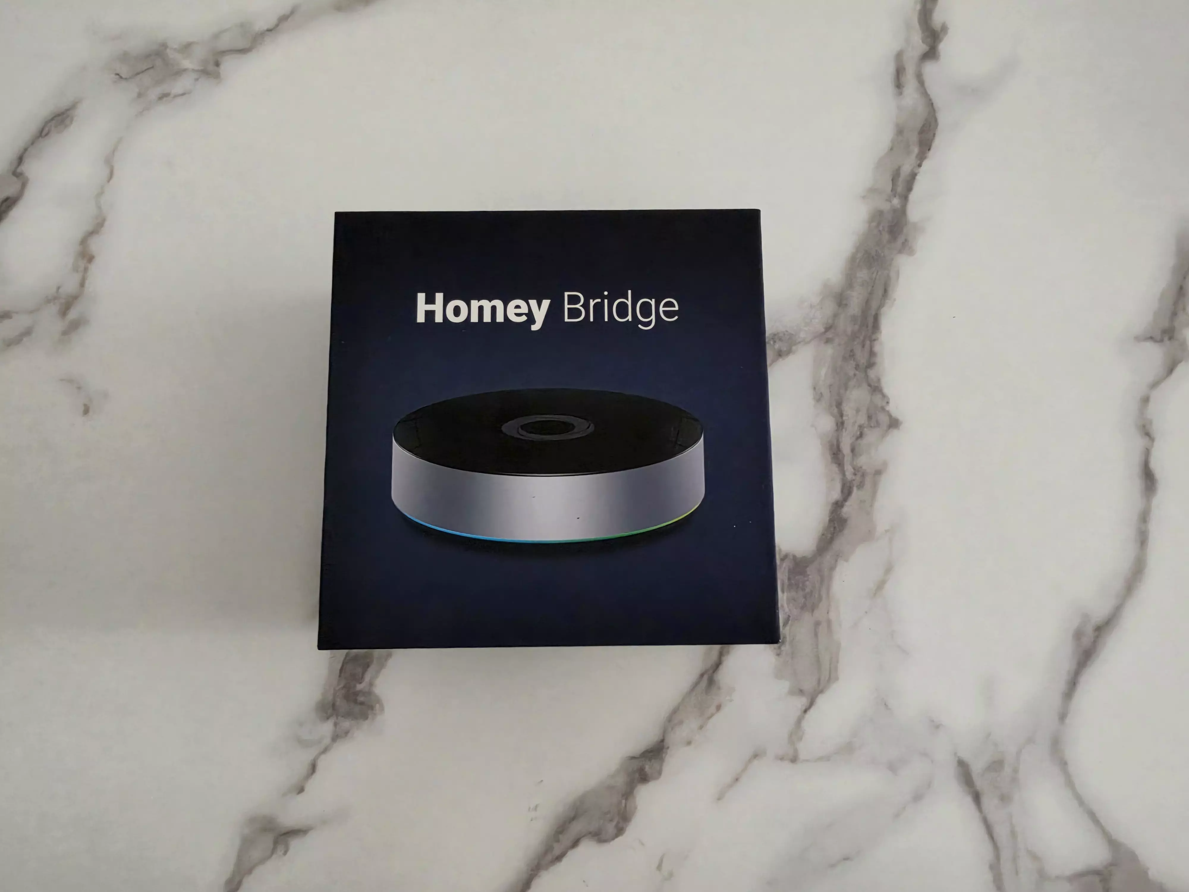 Boîte du Homey Bridge montrant le boîtier circulaire et son anneau lumineux