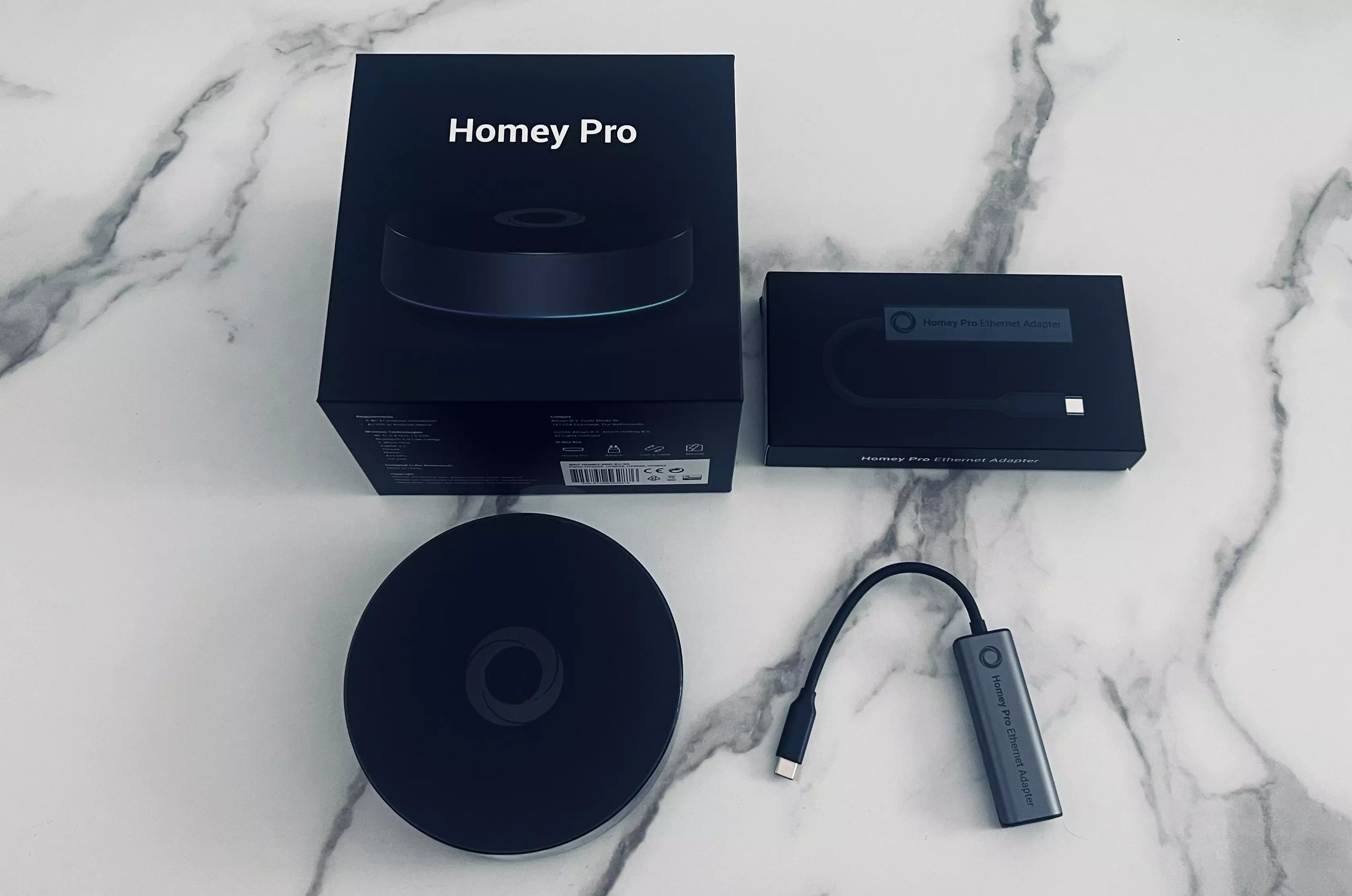 Homey Pro, sa boîte, l’adaptateur Ethernet et leurs emballages réunis