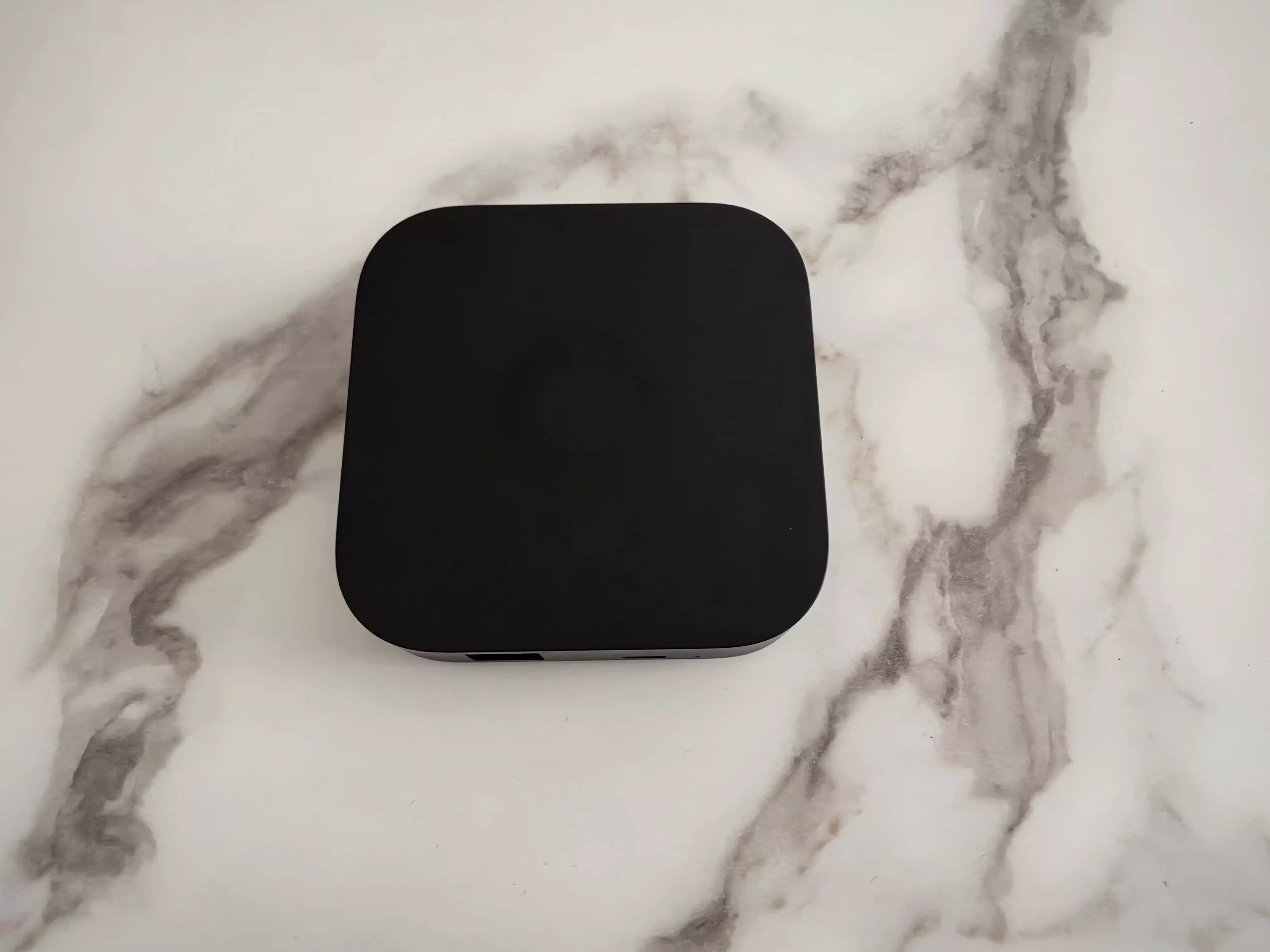 Homey Pro mini noir vu de dessus sur une surface claire