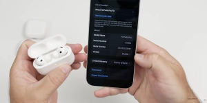 AirPods dans leur boîtier en charge à proximité d’un iPhone pour installer une mise à jour