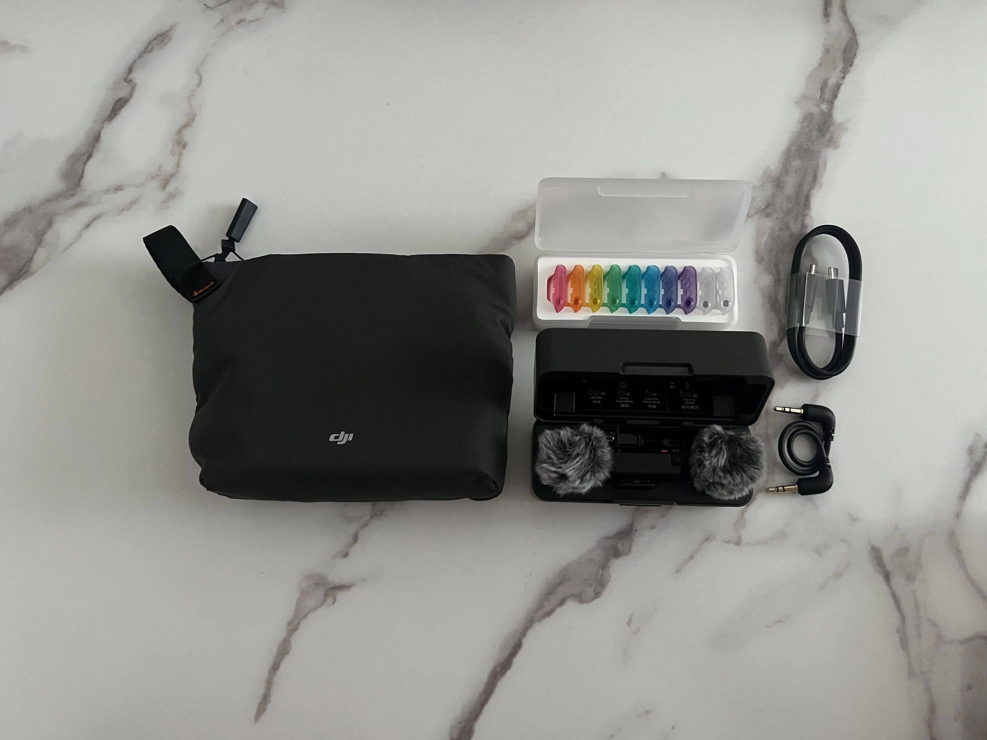 Sacoche DJI, boîtier de recharge ouvert, coques colorées et câbles du Mic Mini 2S