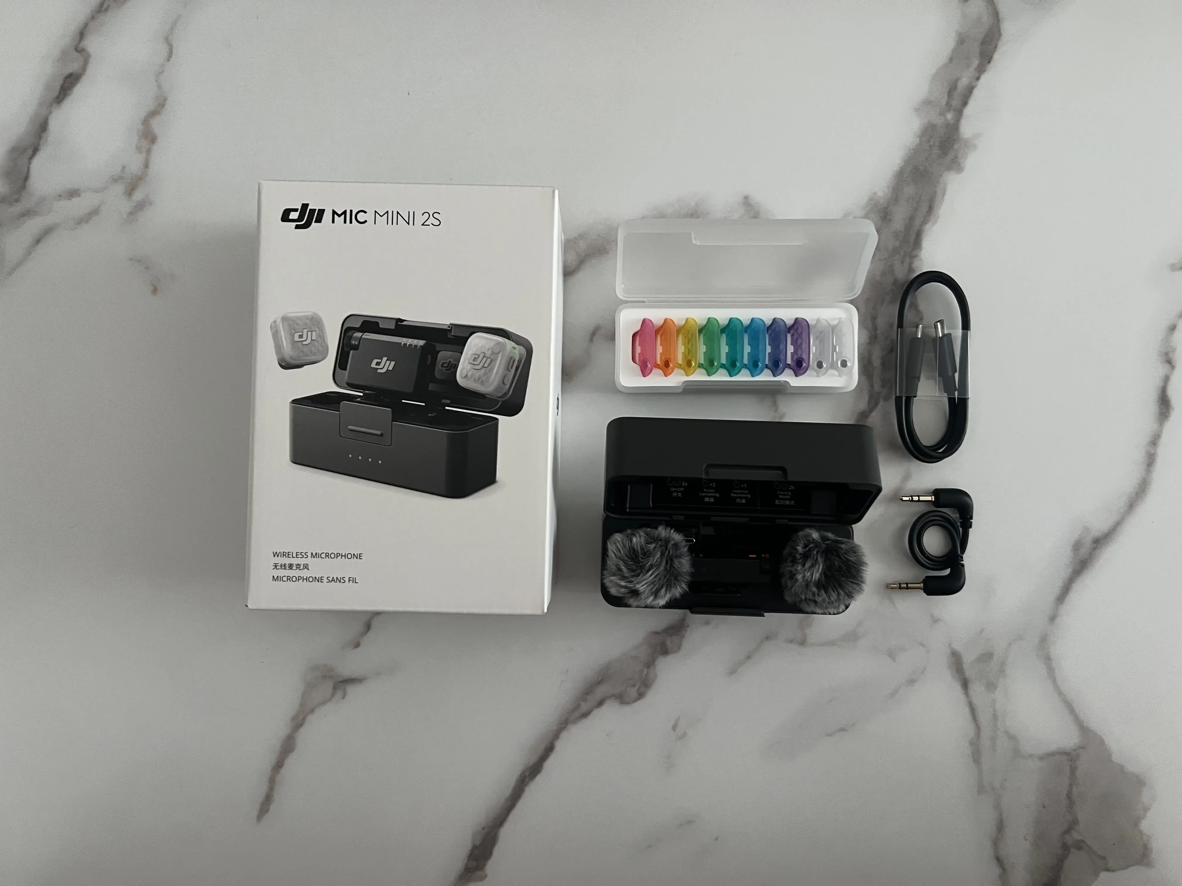 Boîte DJI Mic Mini 2S avec boîtier ouvert, coques magnétiques et câbles