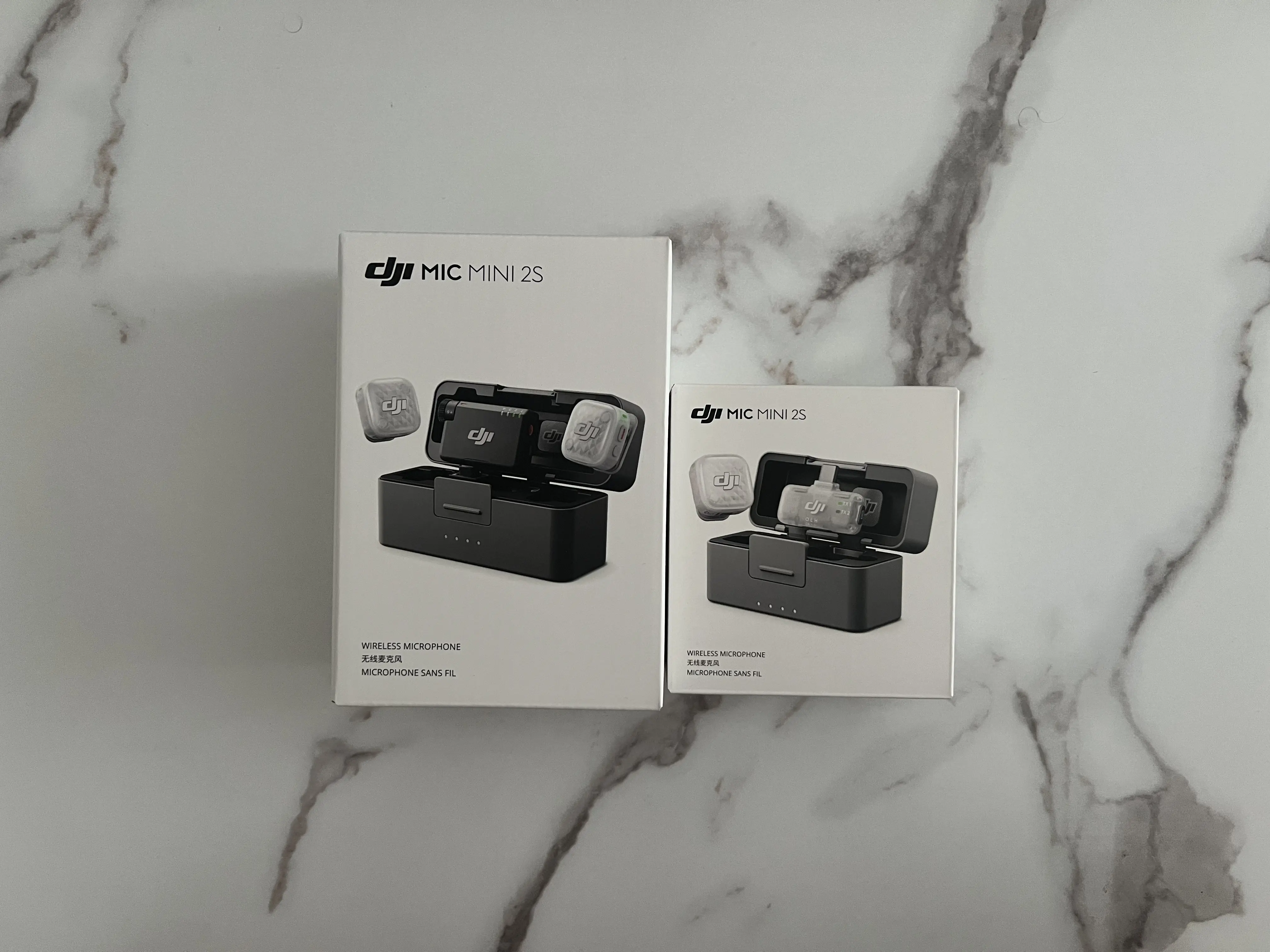 Deux boîtes DJI Mic Mini 2S des versions 2 TX et 1 TX placées côte à côte