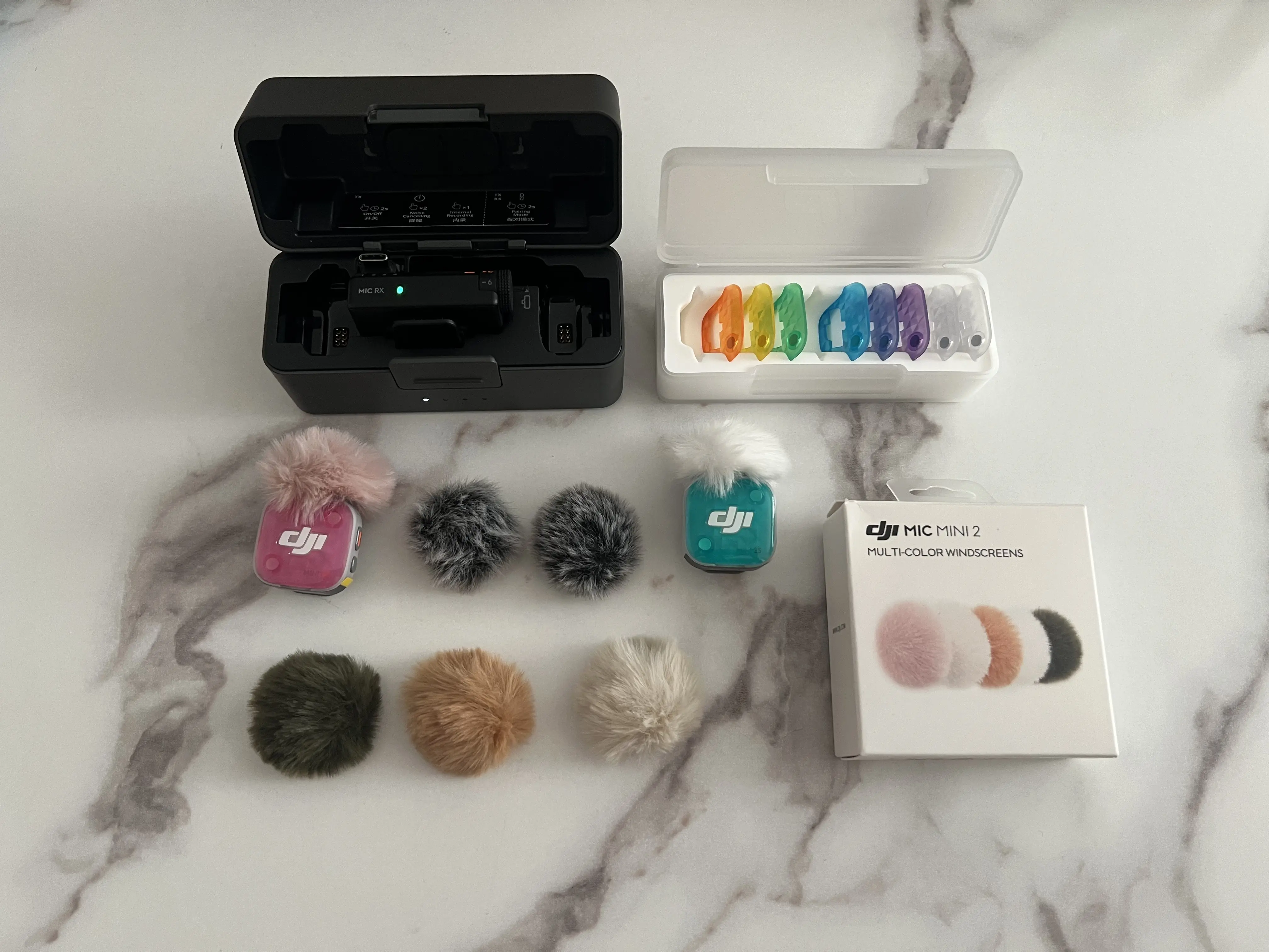Boîtier DJI Mic Mini 2S, coques multicolores, émetteurs rose et turquoise, bonnettes et boîte d’accessoires