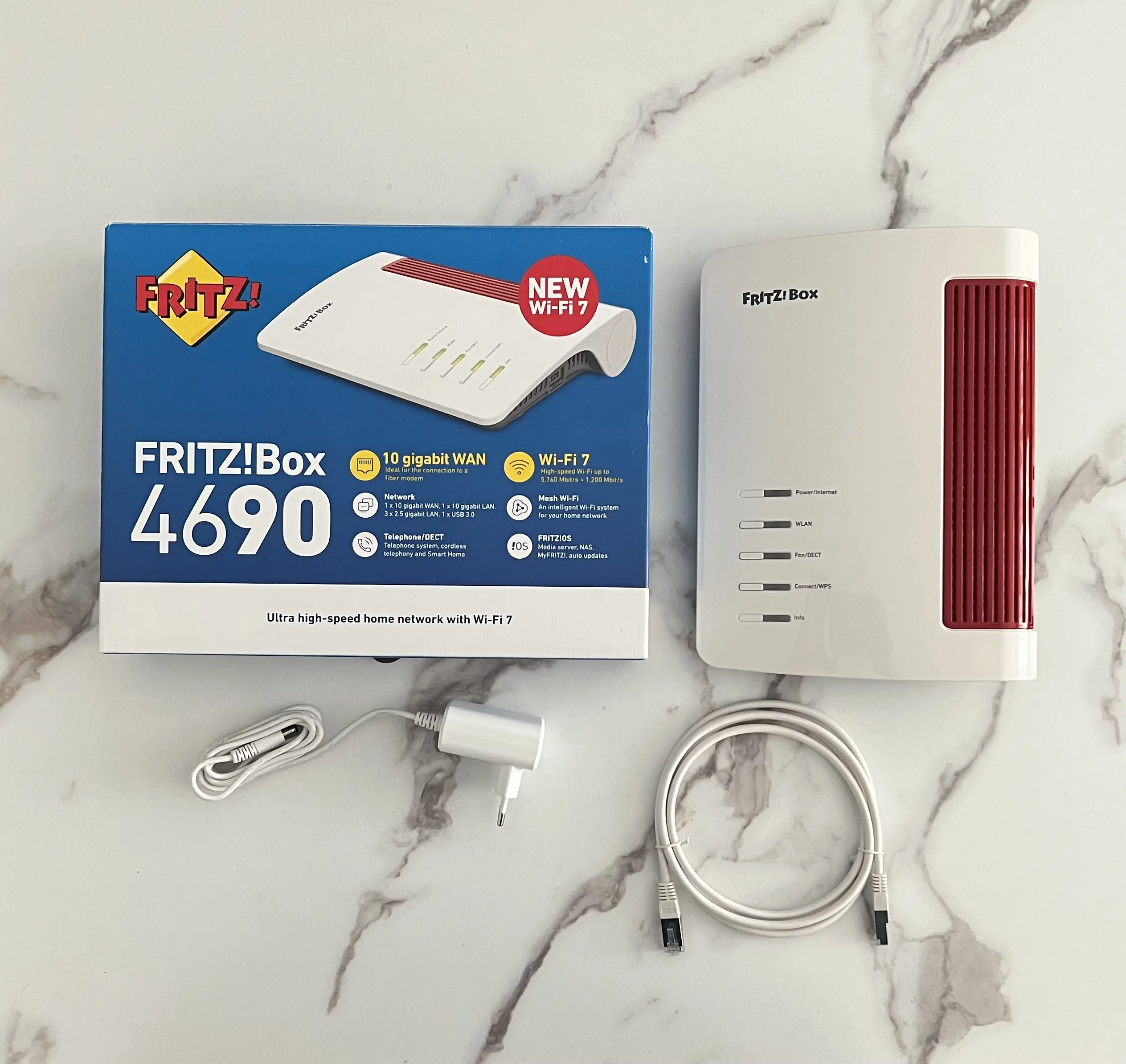 FRITZ!Box 4690 avec sa boîte, son alimentation et son câble Ethernet