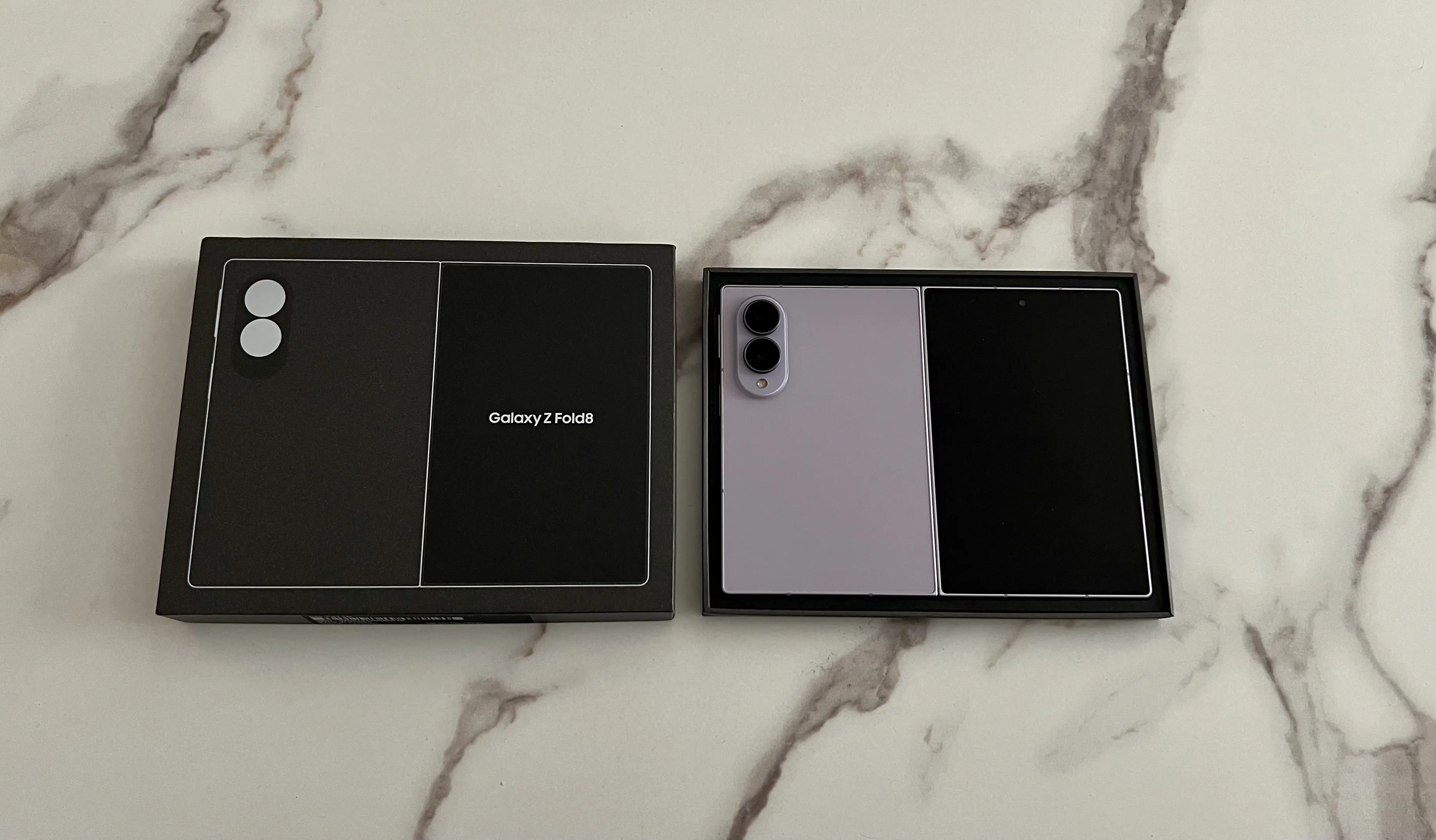Samsung Galaxy Z Fold8 Lavande ouvert dans son coffret à côté de la boîte noire