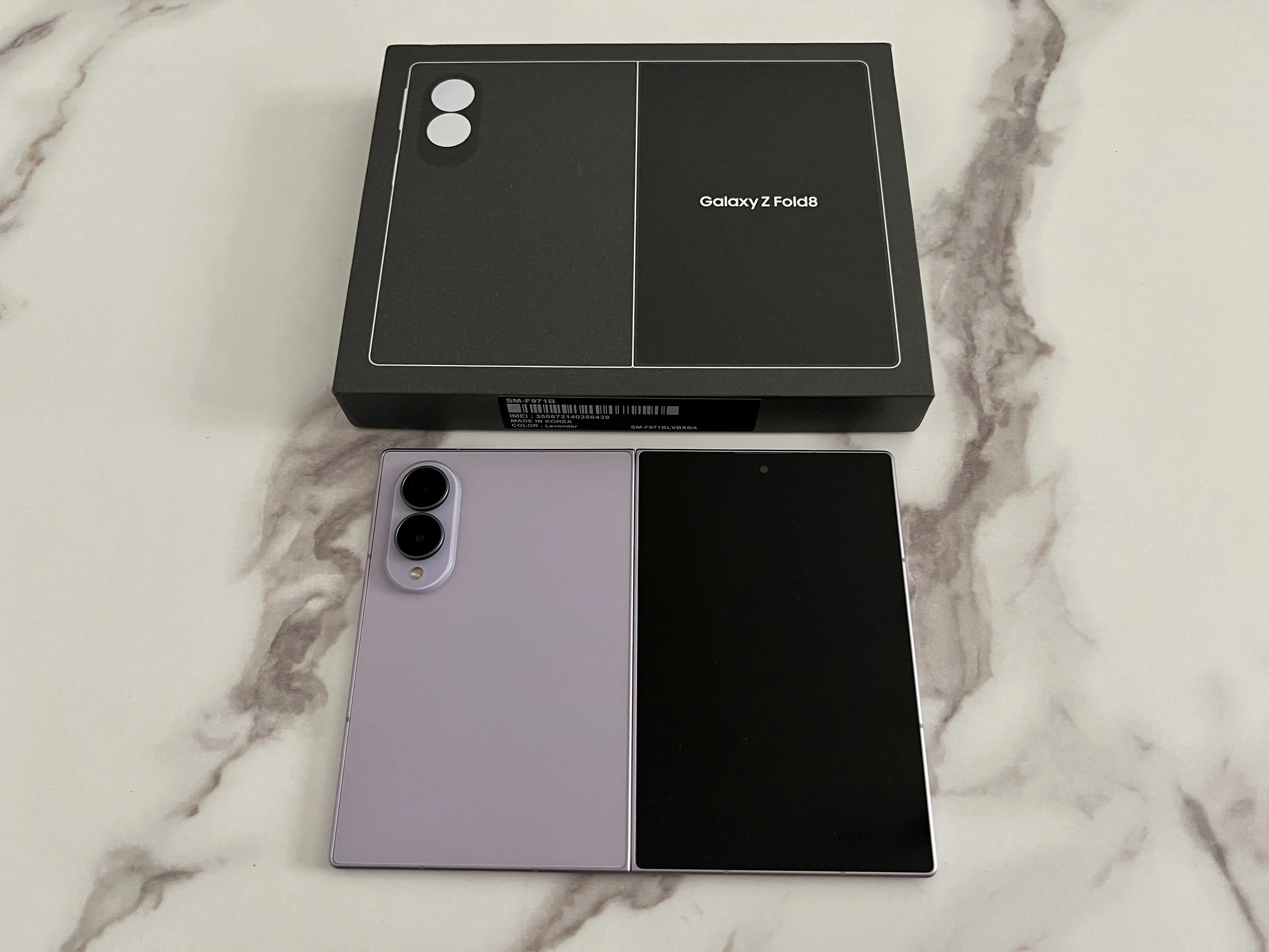 Samsung Galaxy Z Fold8 Lavande ouvert à plat devant sa boîte noire