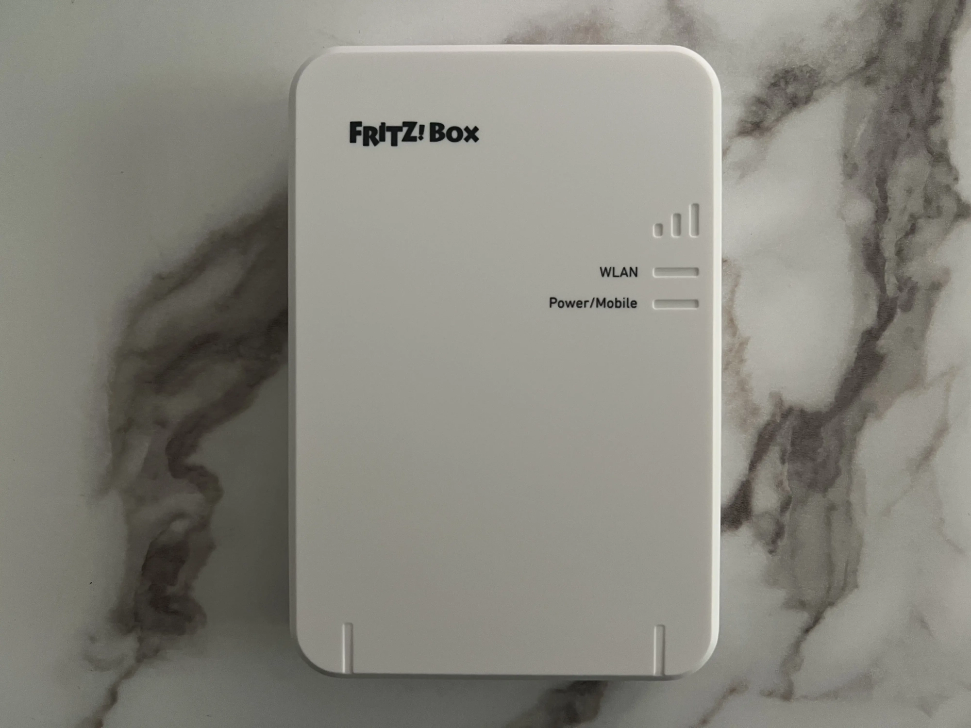 Face avant de la FRITZ!Box 6860 5G avec barres de signal et voyants WLAN et Power/Mobile