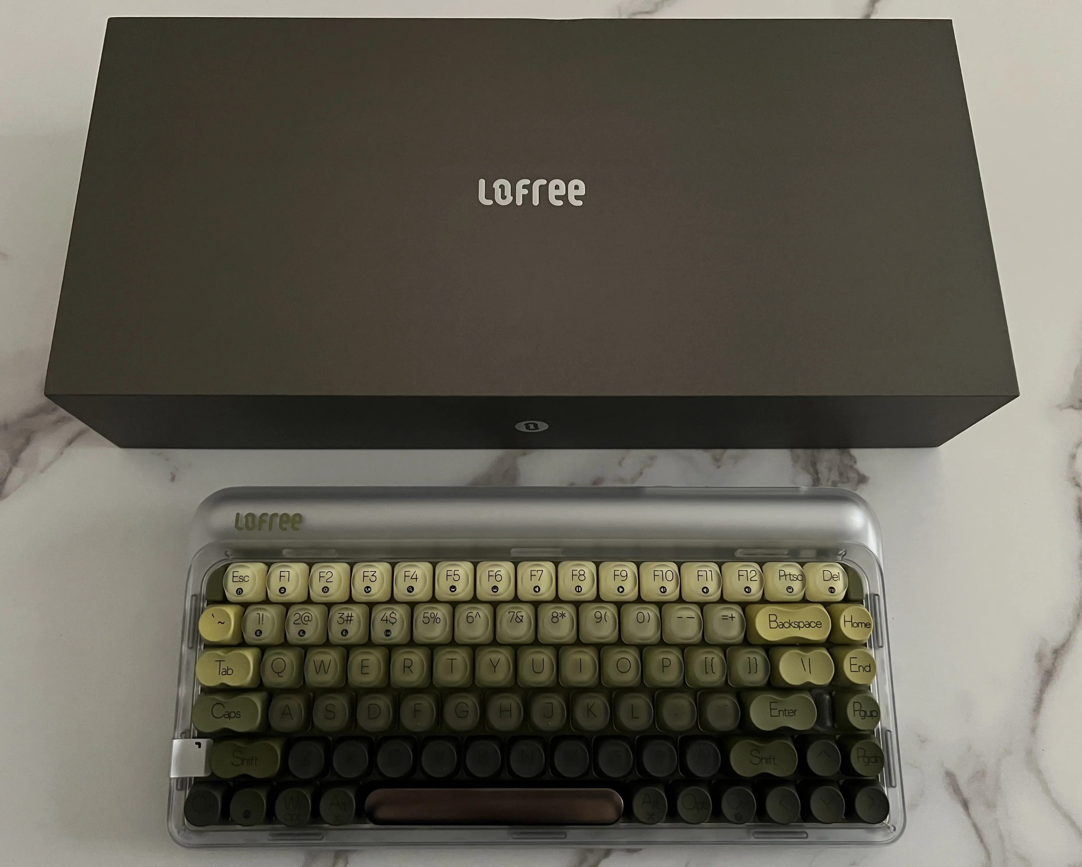 Clavier Lofree 432Hz Polar Moss éteint avec touches vertes dégradées et châssis translucide devant sa boîte